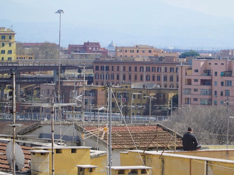 A man sits alone on a roof terrace during Italy's nationwide lockdown in Rome