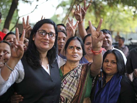 Asha Devi, center, mother of the victim of the fatal 2012 gang rape on a moving bus, displays a victory sign with her lawyer after the rapists of her daughter were hanged in New Delhi, India, Friday, March 20, 2020. 