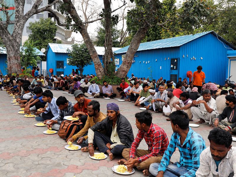 Daily wage workers and homeless people eat food inside a government-run night shelter in the old quarters of Delhi.