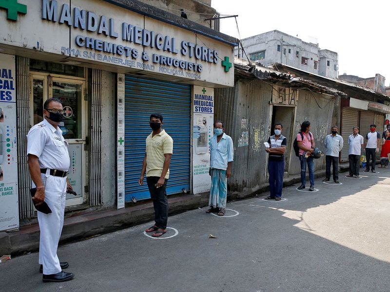 People look on as they stand in circles drawn to maintain safe distance while waiting to buy medicine during a 21-day nationwide lockdown to limit the spreading of Coronavirus disease (COVID-19), in Kolkata.