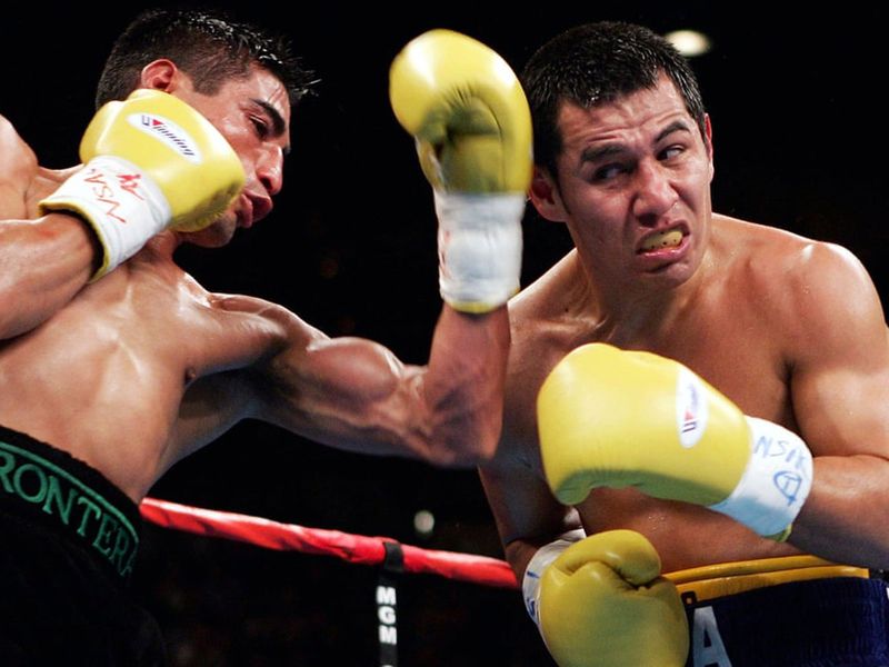 Erik Morales throws a glancing blow to the head of Marco Antonio Barrera during their third fight, in 2004.