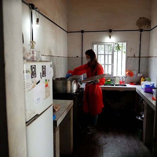 A volunteer wearing a face mask stirs the stew that she's preparing for the low-income people at a soup kitchen during the spread of the COVID-19, in Florencio Varela, in the outskirts of Buenos Aires, Argentina. 