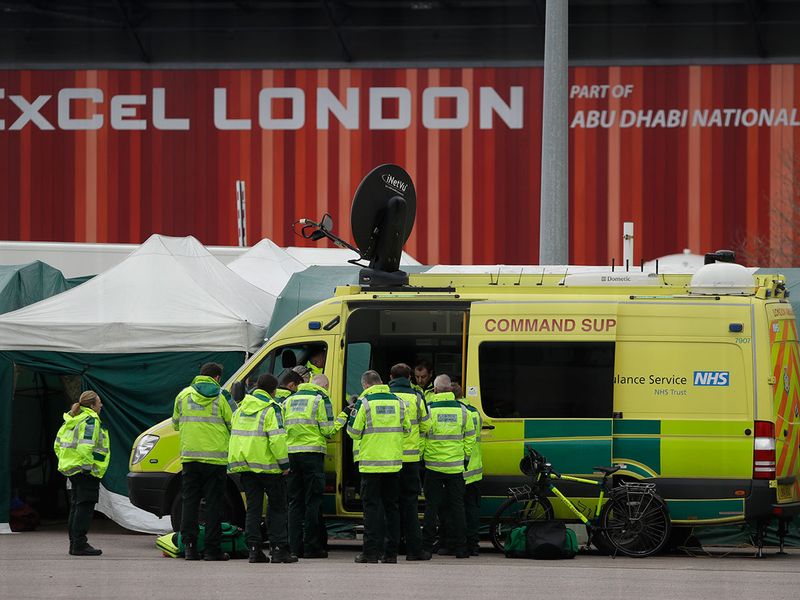 Paramedics and ambulance personnel get instructions from a command unit outside the ExCel center.  