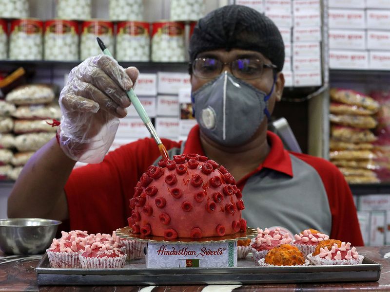 A confectioner applies finishing touches to a replica of coronavirus made out of sweets at a confectionary workshop in Kolkata.