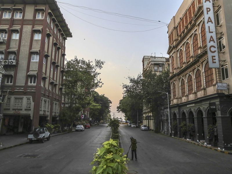A man cleans up a street in the Colaba area during a lockdown imposed due to the coronavirus in Mumbai. 