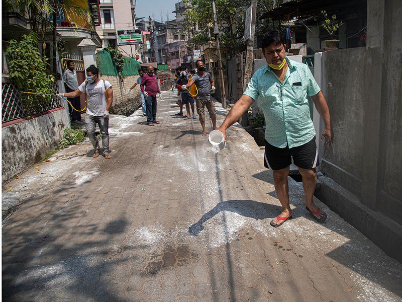 Residents sanitize their locality as a preventive measure against the COVID-19 corona in Gauhati. 