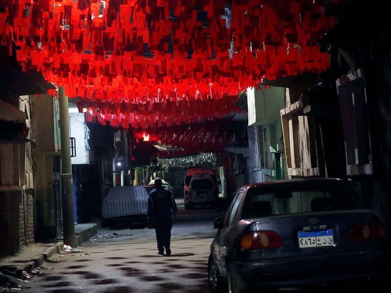 A man walks in front of closed shops and decorations for the Muslim holy month of Ramadan which also know for Egyptians as 