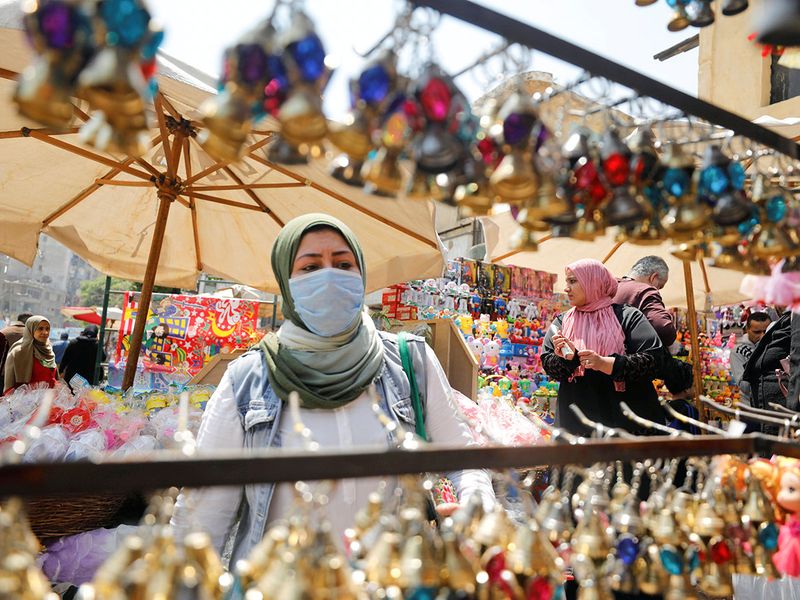 A woman wearing a protective face mask amid concerns over the COVID-19 buys traditional Ramadan lanterns, called 