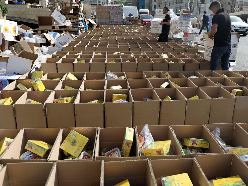 Volunteers fill up carton boxes with food items to be distributed to needy Palestinian families, ahead of the Ramadan fasting month, in the occupied West Bank city of Nablus.