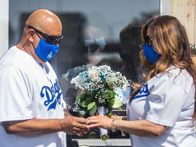 Philip Hernandez (L) puts the ring on his bride Marcela Peru, as Clerk Recorder Erika Patronas (C) looks on, during their wedding ceremony