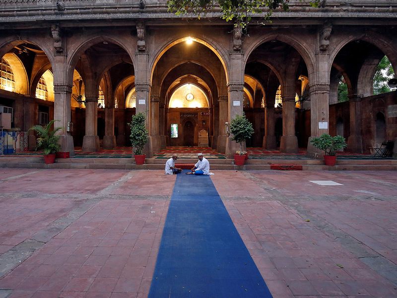 Two men eat their Iftar meals inside an almost empty Sidi Saiyyed mosque during Ramadan. A nationwide lockdown until May 3rd has been announced in India to slow the spread of the COVID-19.