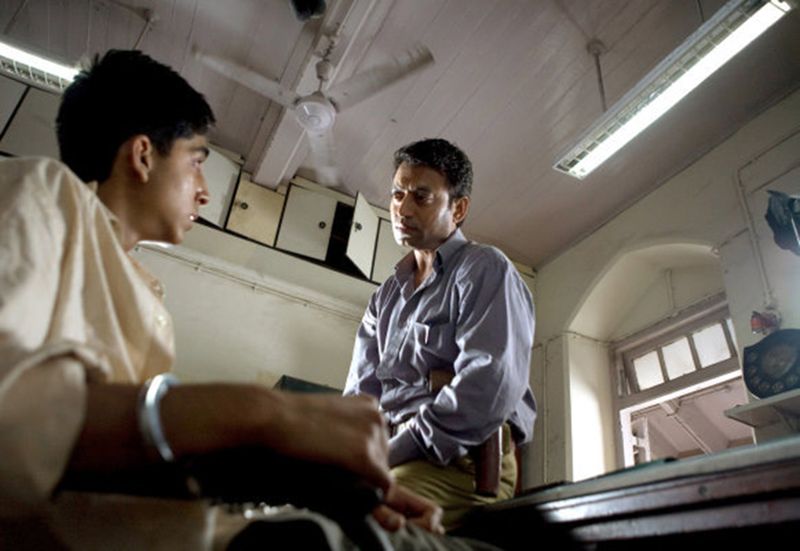 Irrfan Khan with Dev Patel in Slumdog Millionaire