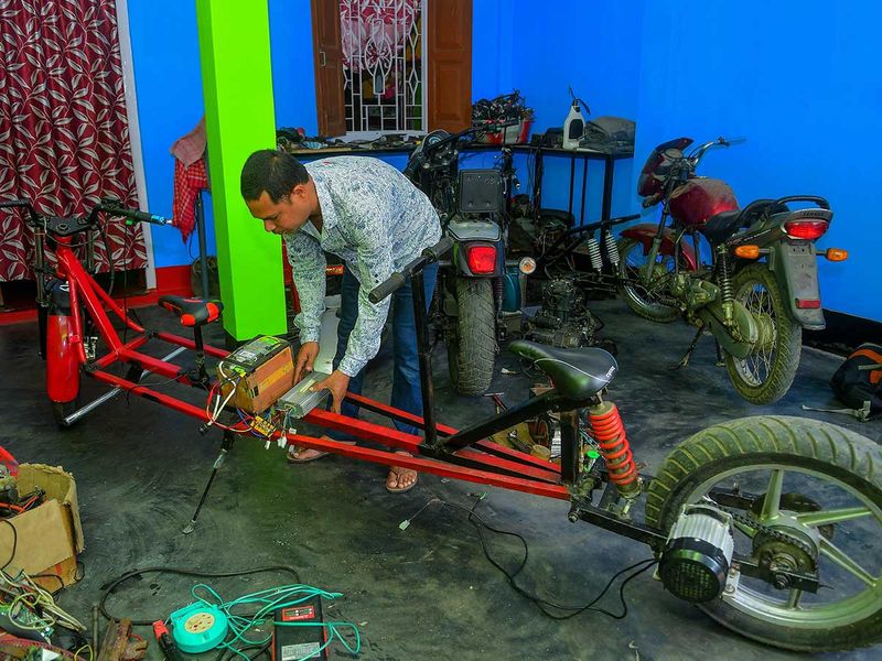 Partha Saha assembles his modified bike designed for social distancing 