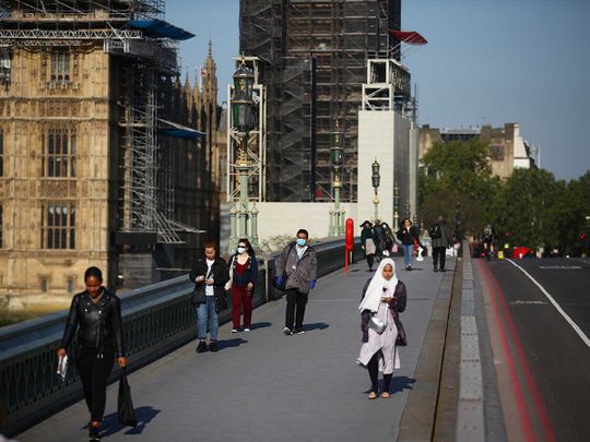 People walk across Westminster Bridge in London 