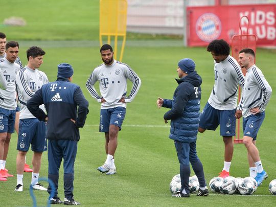 Bayern Munich's headcoach Hansi Flick (C) talks to his players during a training session at the football team's training grounds in Munich, southern Germany, on May 5, 2020.  German authorities are expected to decide on May 6, 2020 whether to allow the Bundesliga to resume, making it the first league to restart in Europe, behind closed doors and on the basis of a draconian health protocol. / AFP / Christof STACHE