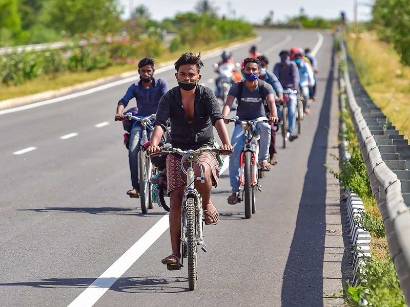 Migrants from Uttar Pradesh and Bihar ride their bicycles