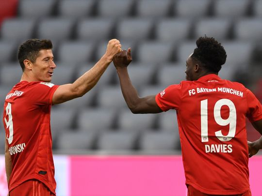 Bayern Munich's Robert Lewandowski, left, and teammate Alphonso Davies celebrate the fifth goal against Fortuna Duesseldorf 