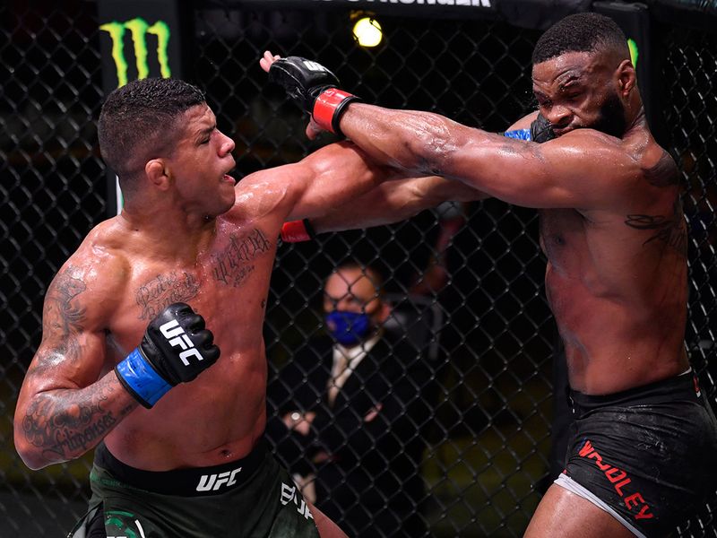 Gilbert Burns of Brazil (blue gloves) punches Tyron Woodley (red gloves) in their welterweight fight during UFC Fight Night.