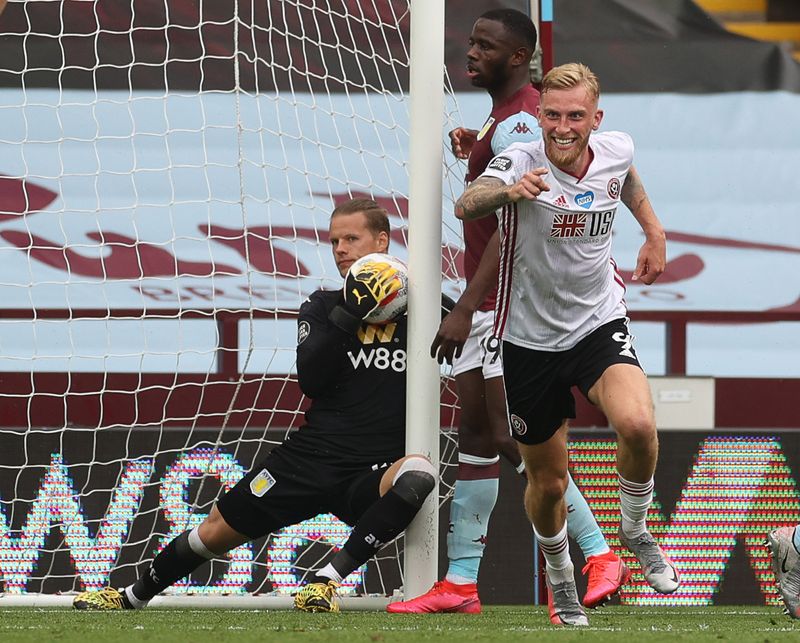 Sheffield United's Oliver McBurnie turns to celebrate as Aston Villa Orjan Nyland looks on. No goal was given despite the ball crossing the line.