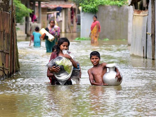 Assam flood children wade