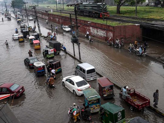 Commuters flood street monsoon rain Lahore Pakistan