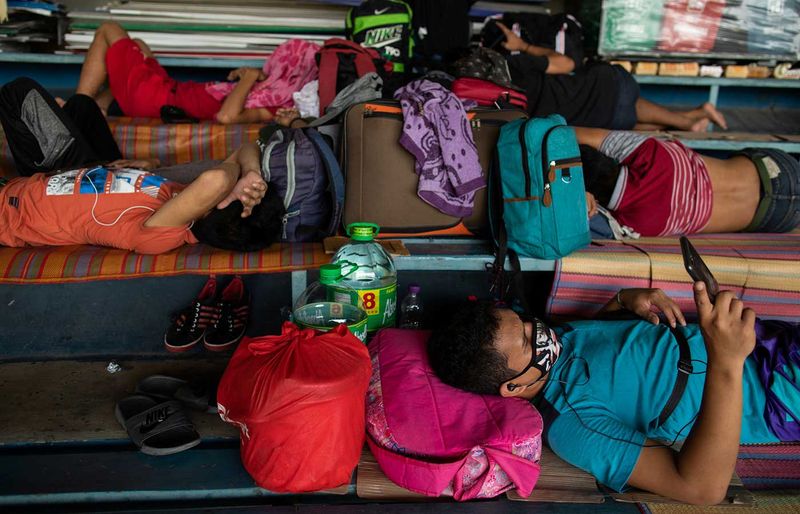 Filipinos stranded due to the coronavirus disease (COVID-19) restrictions sleep on the bleachers of a baseball stadium while waiting to be transported back to their provinces through a government transportation program, in Rizal Memorial Sports Complex, Manila, Philippines, July 25, 2020. REUTERS/Eloisa Lopez