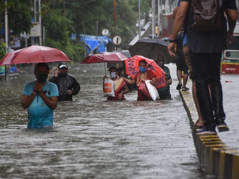 commuters wade flood rain Mumbai