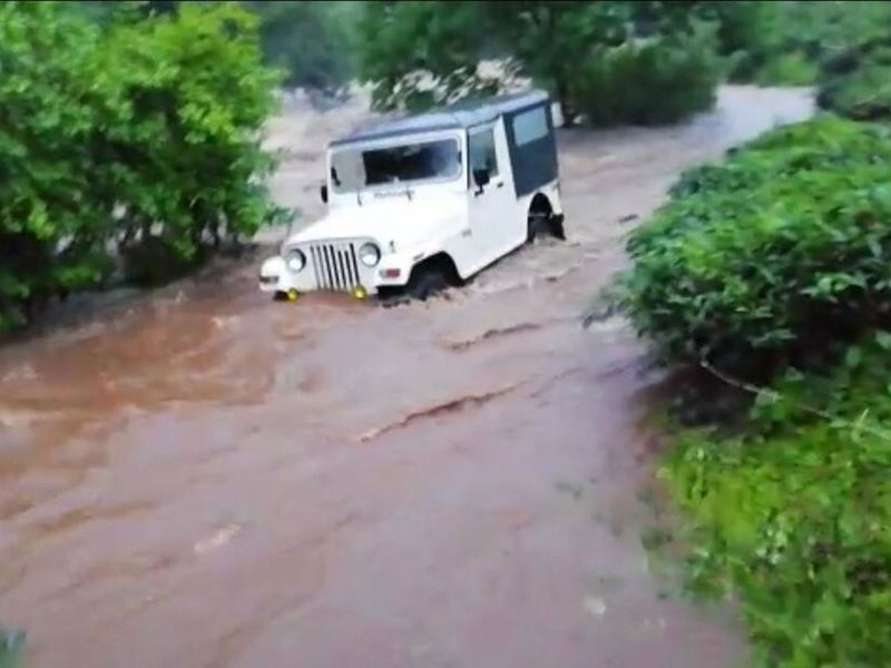A vehicle tries to cross a heavily flooded route