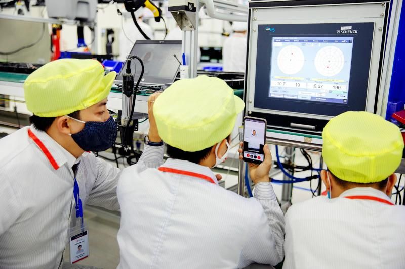 PROGRESS REPORT: Employees make a phone call to report progress and receive guidance while working on the ventilator production line at the Vinsmart factory, operated by Vingroup JSC, in Hanoi, Vietnam.