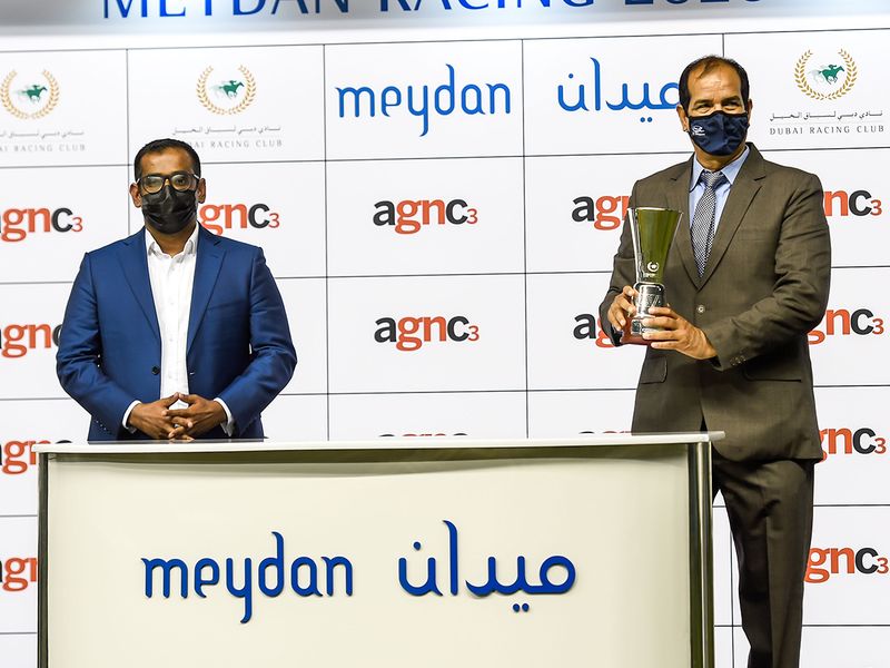 David George presenting the winners trophy to Maksood Ali after Lavaspin won the agnc3 race at Meydan