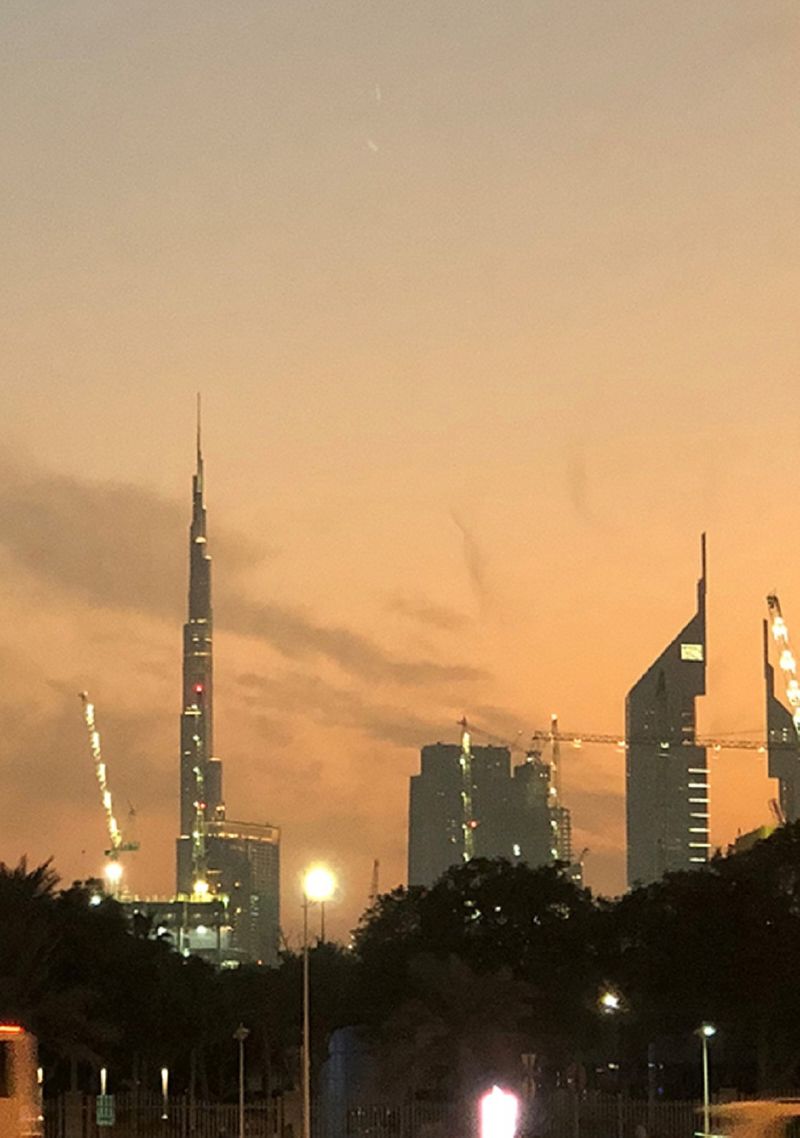 Building never stops. Cranes form part of Dubai's skyline marked by the city's most iconic skyscrapers in this shot taken at dusk.