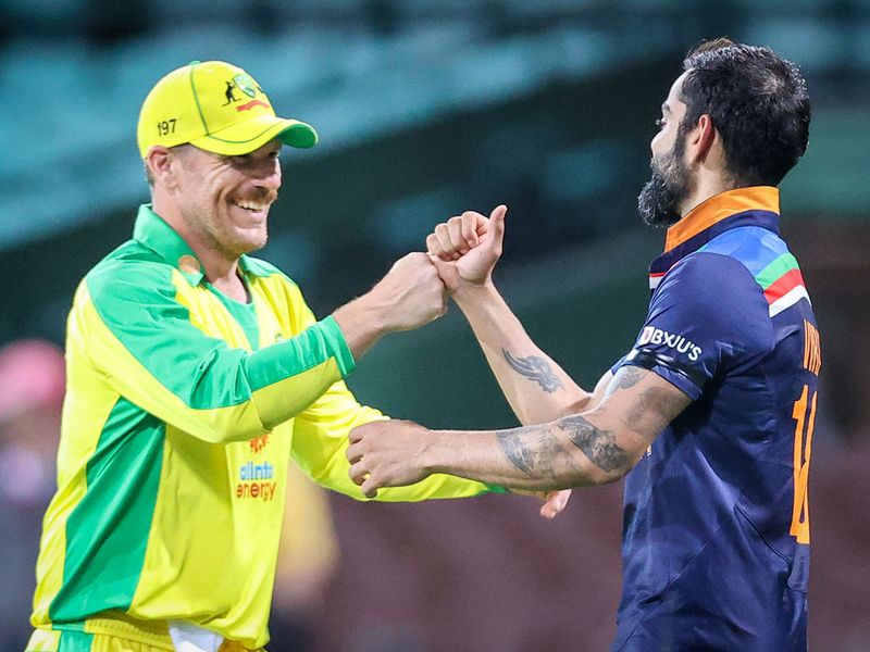 Australia's captain Aaron Finch (L) bumps fists with India's captain Virat Kohli 