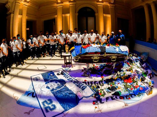 Members of Argentine football team Gimnasia y Esgrima La Plata pay tribute to the coffin of Diego Maradona