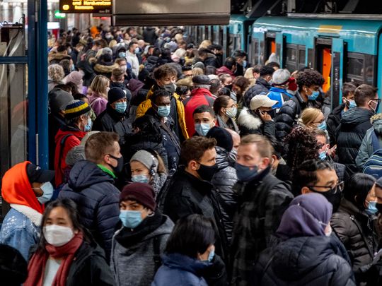 People with face masks stand close together as they wait for a subway train in Frankfurt, Germany, Wednesday, Dec. 2, 2020.