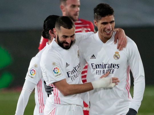Real Madrid's Raphael Varane, right, celebrates the win over Granada with Karim Benzema