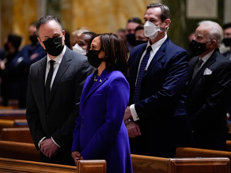Doug Emhoff looks at his wife Vice President-elect Kamala Harris as they attend Mass at the Cathedral of St. Matthew the Apostle during Inauguration Day ceremonies, in Washington. 