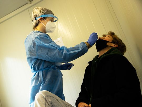A medical worker takes a nose swab from a traveller to be tested for COVID-19 at the Zaventem international airport in Brussels.  