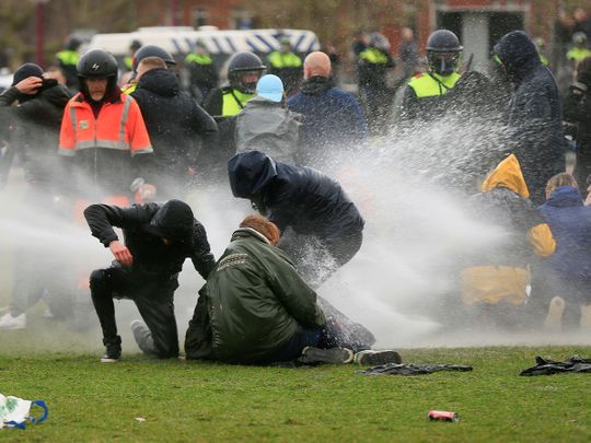 Police uses a water canon during a protest against restrictions put in place to curb the spread of COVID-19, in Amsterdam, on January 24, 2021. 
