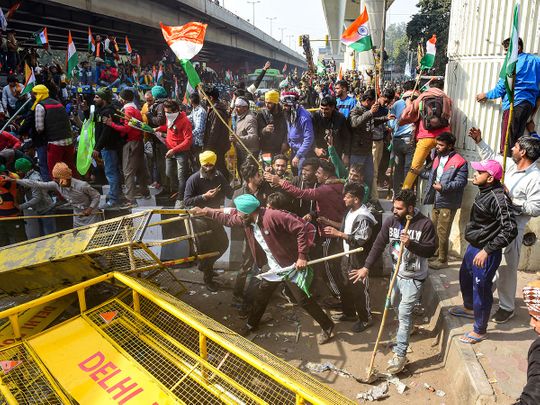 New Delhi: Farmers attempt to break a barricade near Nangloi as they participate in the 'Kisan Gantantra Parade', during their ongoing protest against Centre's farm reform laws, on the occasion of 72nd Republic Day, in New Delhi, Tuesday, Jan. 26,  2021. 
