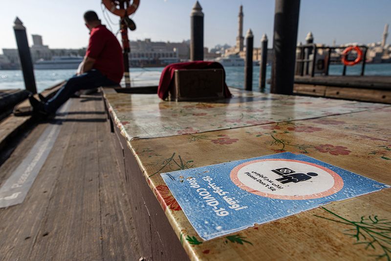 A sign reminds passengers about social distancing on a water taxi, also known as an abra, on the creek in old Dubai.