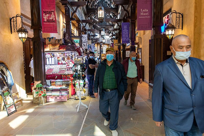 Tourists wearing protective masks walk through the Souk Madinat Jumeirah in Dubai.