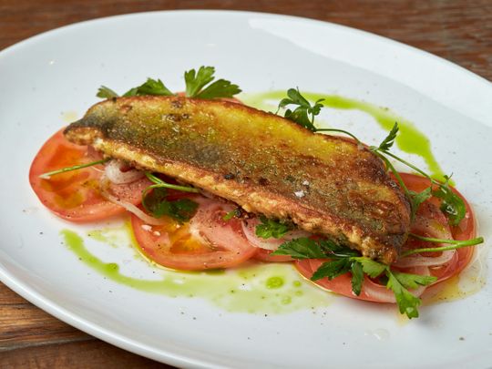 Andalusian-style adobo sea bass with pickled onion, herbed tomato