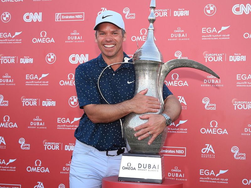 Paul Casey embraces the Coffee Pot trophy after winning the Omega Dubai Desert Classic