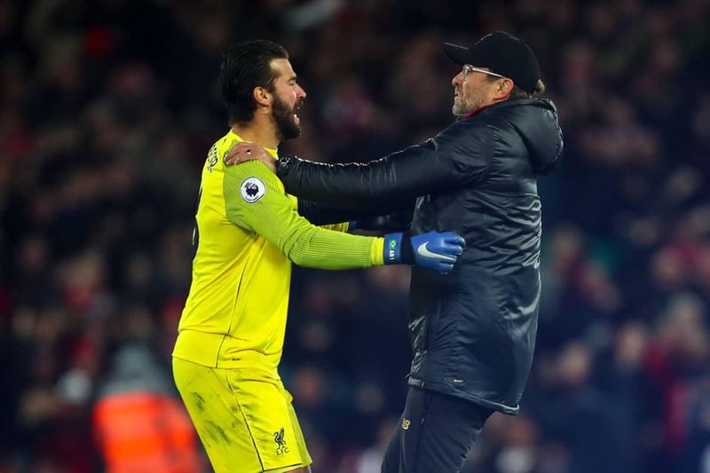 Jurgen Klopp runs onto the pitch to celebrate with Alisson.