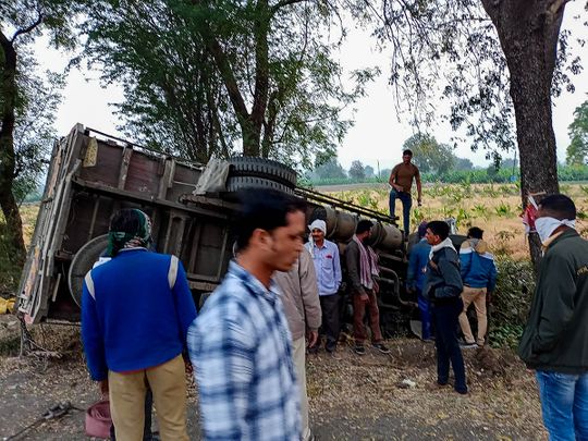 People gather near the mangled remains of a truck after it overturned near Kingaon village, killing atleast 16 labourers, in Jalgaon district of Maharashtra. 