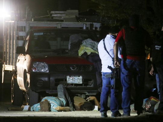 Police investigators work next to the eleven people who were killed when unidentified gunmen riding in a SUV opened fire in Tonala, State of Jalisco, on February 27, 2021. 