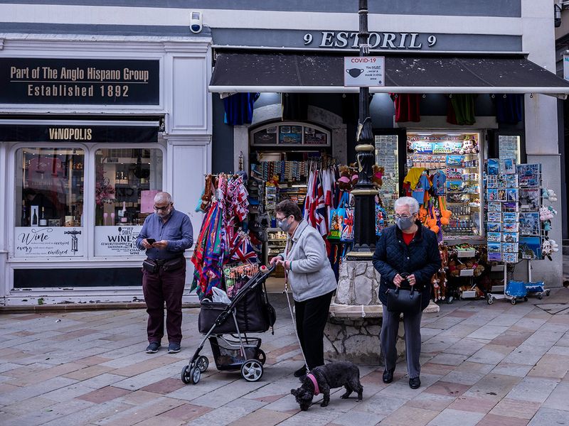 Two elderly woman walk past a souvenir shop in Gibraltar. 