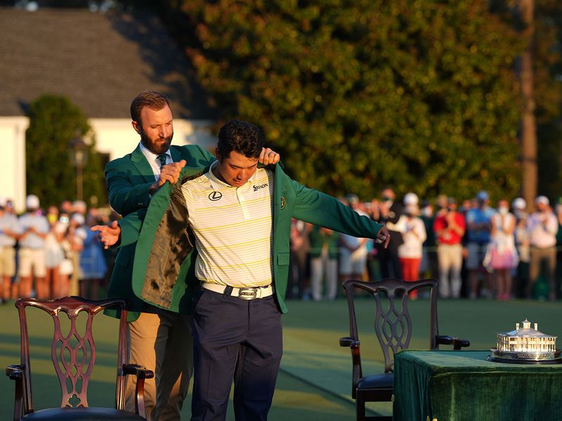 Dustin Johnson, left, the 2020 Masters Tournament champion, helps Hideki Matsuyama put on his green jacket after winning the 2021 Masters Tournament at Augusta National 