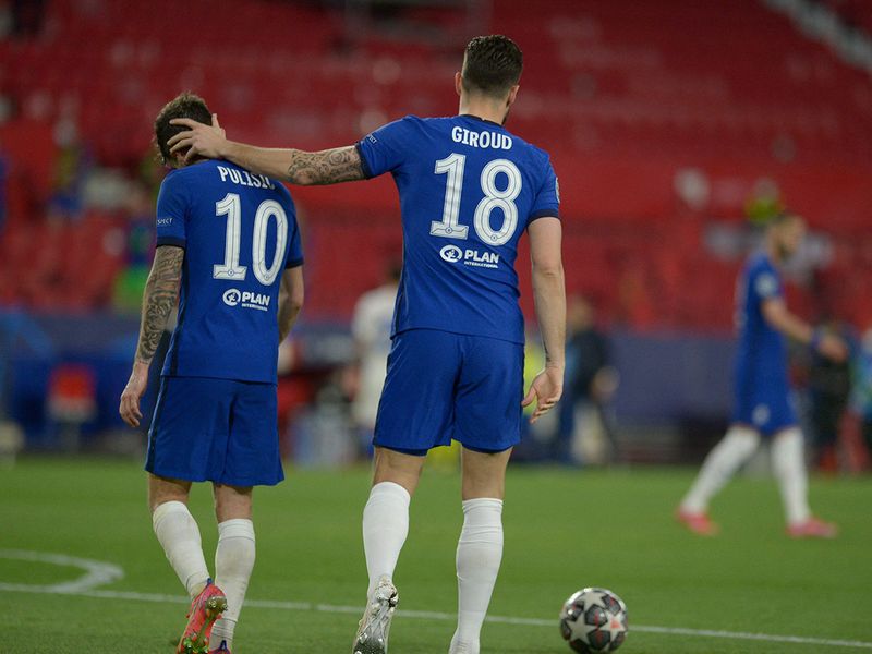 Chelsea striker Olivier Giroud (right) puts a hand on Christian Pulisic's head after the UEFA Champions League quarter final second leg football match between Chelsea and Porto at the Ramon Sanchez Pizjuan stadium in Seville on April 13, 2021.