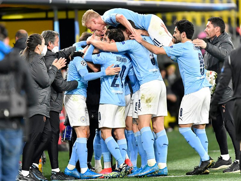 Manchester City's head coach Pep Guardiola celebrates with goal scorer Manchester City's Phil Foden during the Champions League quarterfinal second leg soccer match between Borussia Dortmund and Manchester City at the Signal Iduna Park stadium in Dortmund, Germany, Wednesday, April 14, 2021. (AP Photo/Martin Meissner, Pool)